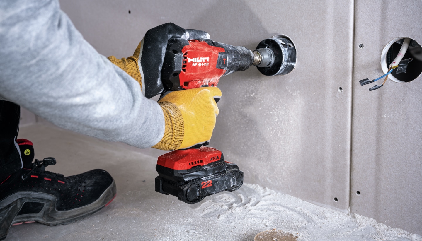 Arbeiter bohrt mit SF 4H-22 in Trockenbauwand