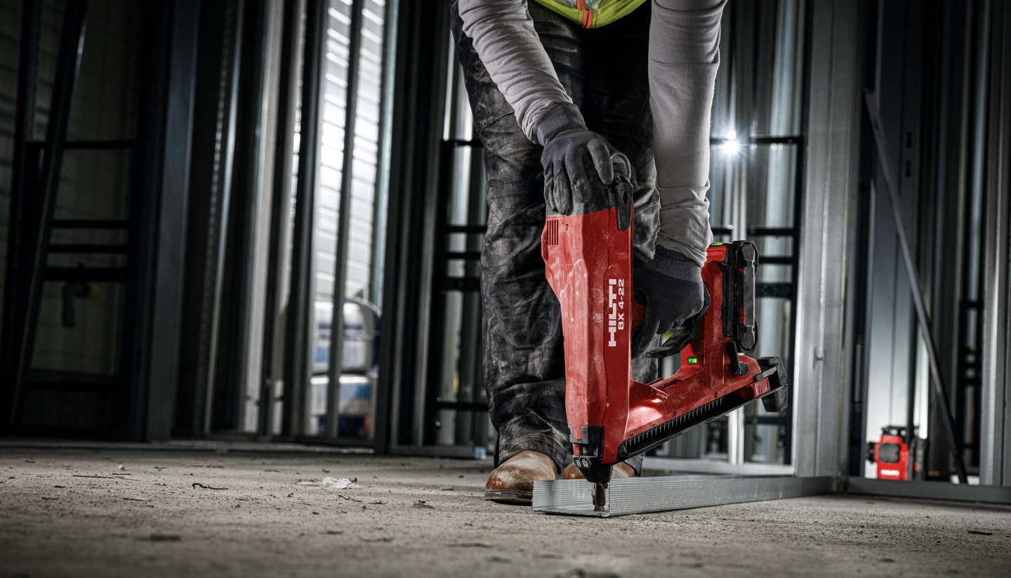 Bauarbeiter beim Anbringen von Metallprofilen auf dem Boden mit dem Hilti BX4-22 und der Batterie B22-85