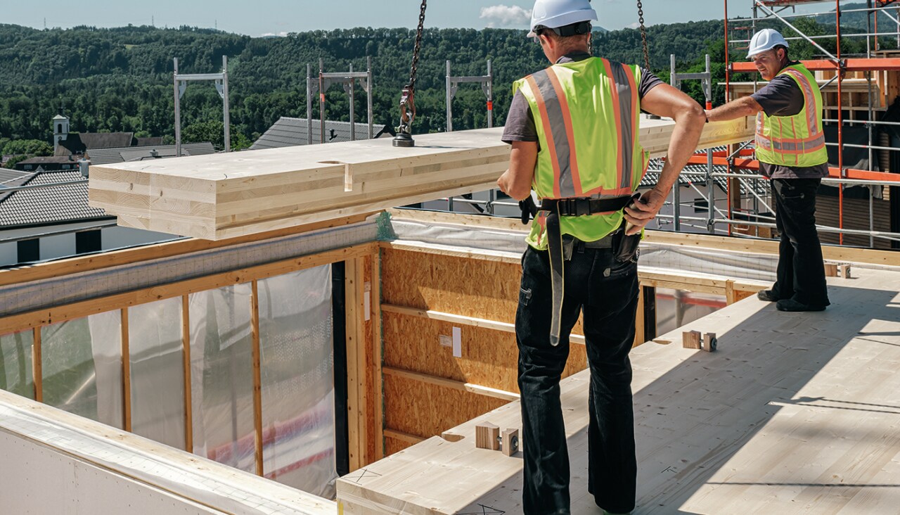 zwei Arbeiter auf der Baustelle mit CLT-Deckenpaneel
