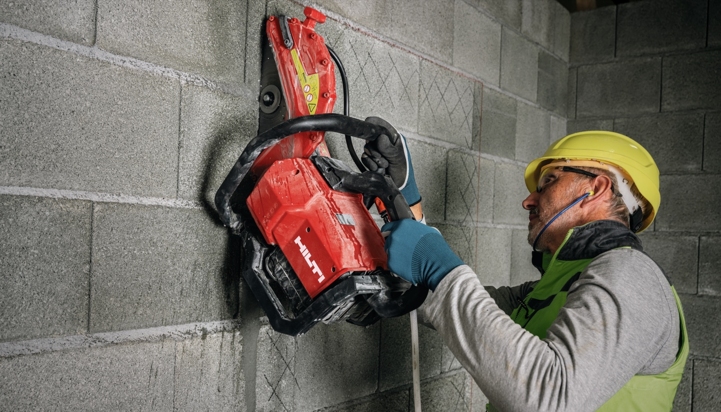 Arbeiter beim vertikalen Schneiden von Beton mit Hilti Betonsäge
