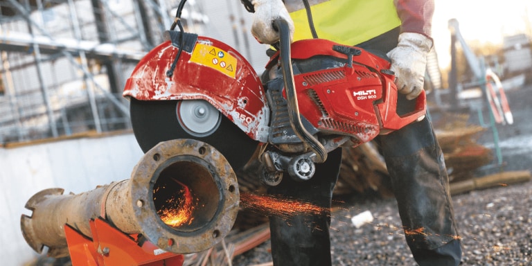 Arbeiter mit Benzintrennschleifer DSH 900-X beim Schneiden von Metall