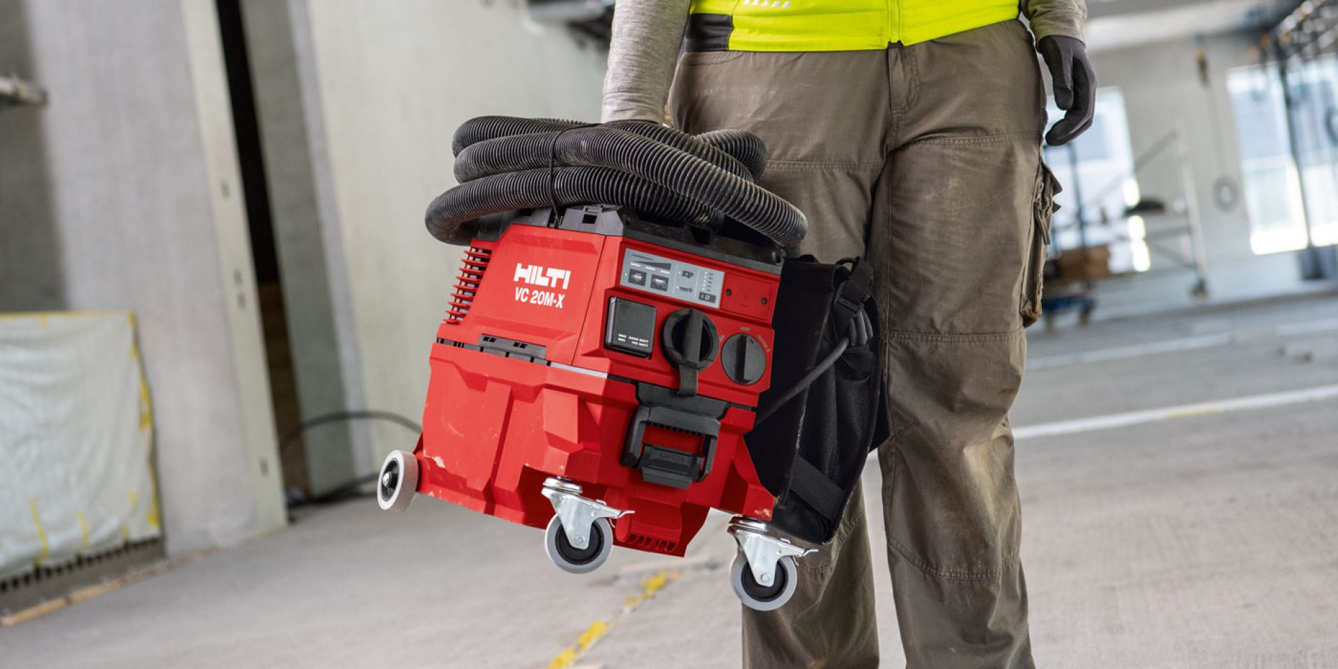 Ein Bild eines Arbeiters, der einen Hilti VC 20M-X M-Klasse Staubabscheider auf der Baustelle trägt