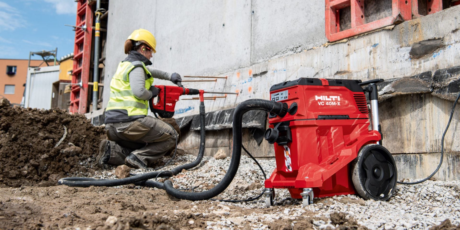 Ein Bild eines Arbeiters, der auf der Baustelle mit einem VC 40M-X Baustellensauger der M-Klasse arbeitet.
