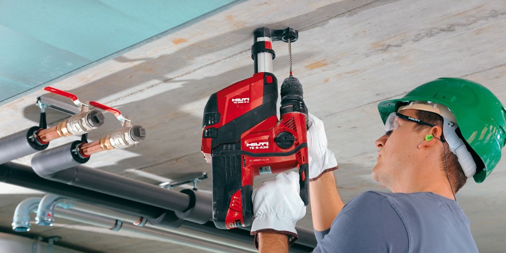 Ein Bild mit einem Arbeiter bei Arbeiten an der Decke mit Hilti Bohrmaschine TE 6-A36 mit Staubmodul TE DRS-6-A