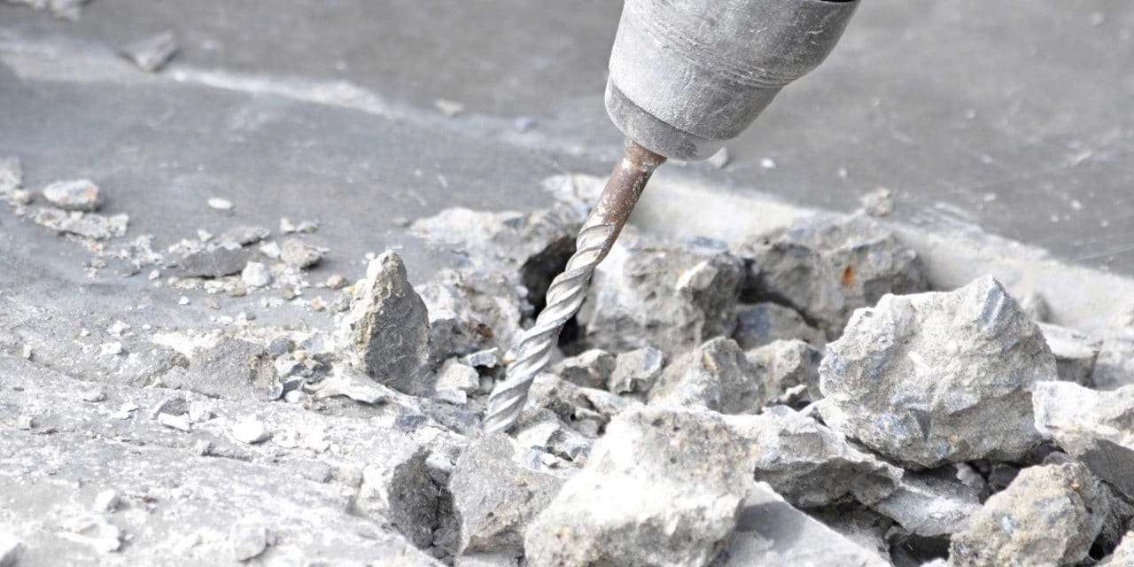 Ein Bild mit einem Bohrer und zerstörtem Betonmaterial