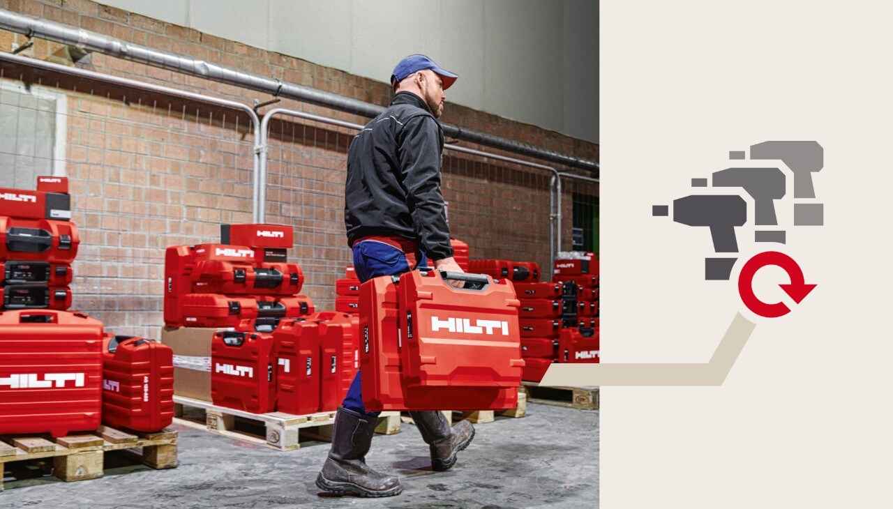 Ein Arbeiter trägt Hilti Koffer auf einer Baustelle.