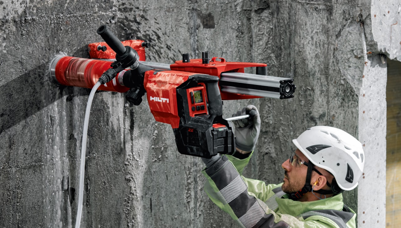 Ein Mann bedient das kabellose Hilti Nuron Kernbohrgerät DD 150-U an einer Wand.