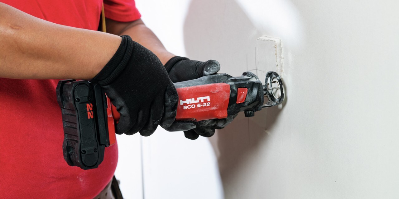 Ein Arbeiter arbeitet mit der Hilti Akku-Spiralsäge SCO 6-22 auf einer Trockenbaustelle