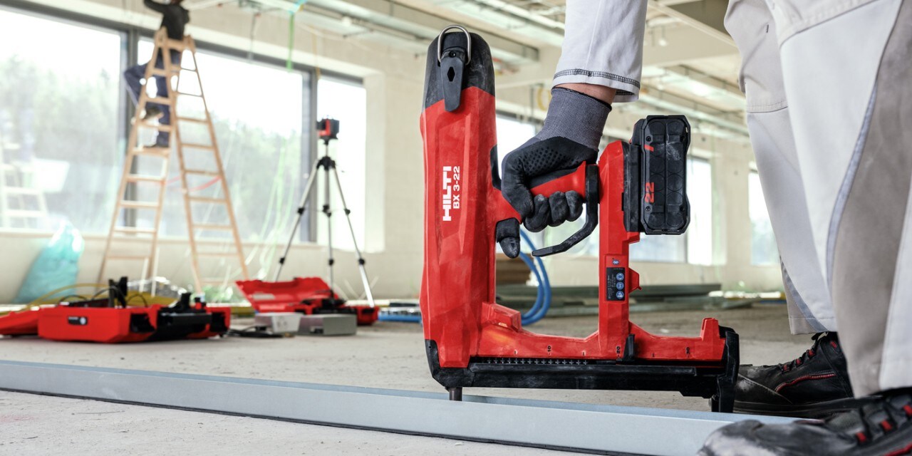 Ein Arbeiter arbeitet mit dem Hilti Akku-Bolzensetzgerät BX 3-ME-22 auf einer Trockenbaustelle