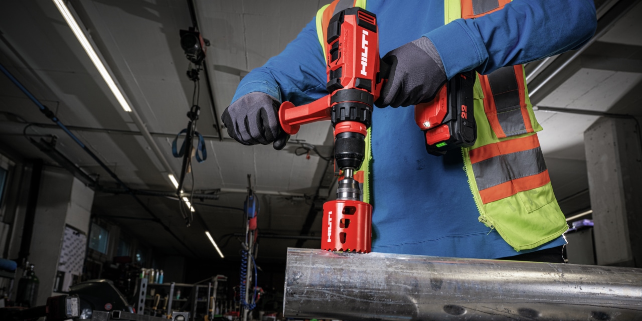 Anwendungsbild des Akkubohrschraubers SF 8M-22 mit Universalbohrfutter und Lochsäge beim Bohren von Stahlrohren
