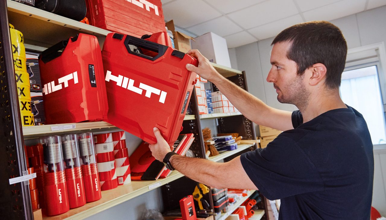 Ein Arbeiter nimmt einen Hilti-Karton aus dem Regal im Lager.