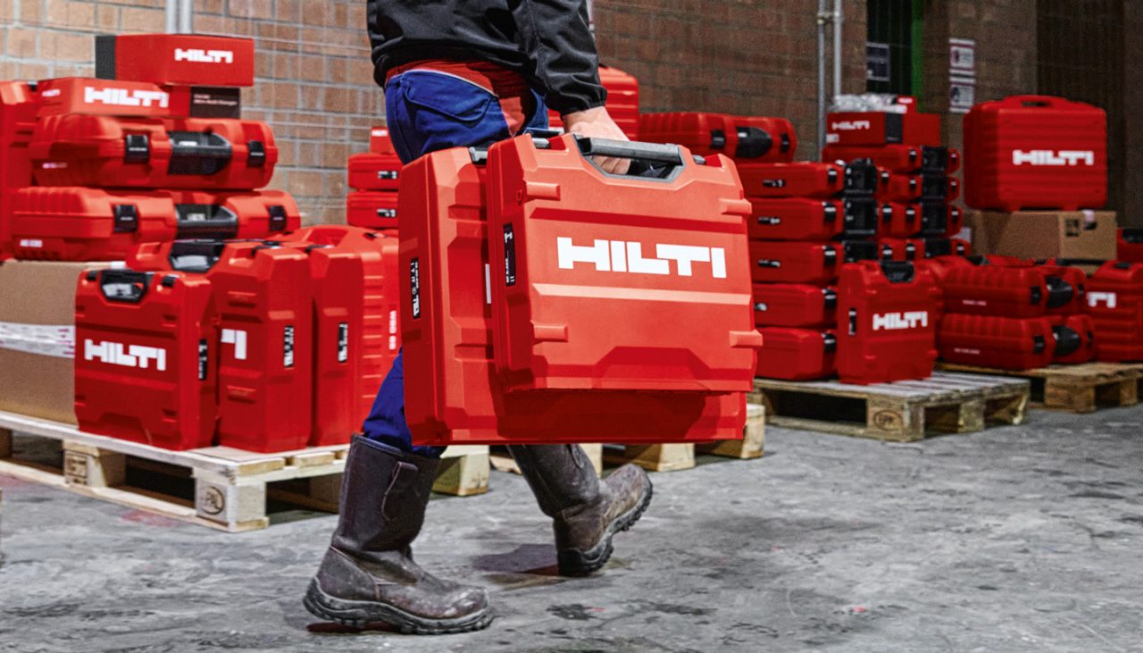 Ein Arbeiter geht mit Hilti-Box herum, im Hintergrund sind weitere Hilti-Boxes zu sehen.