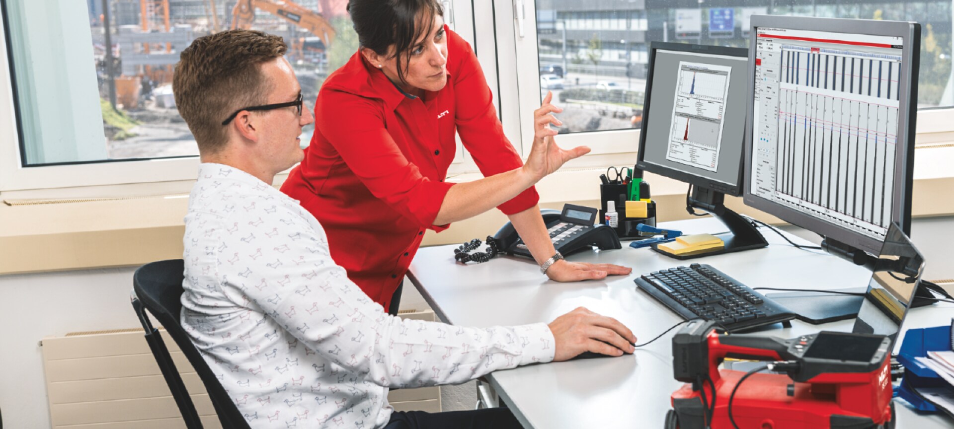 Zwei Ingenieure diskutieren vor einem Computerbildschirm über Verbindungselemente