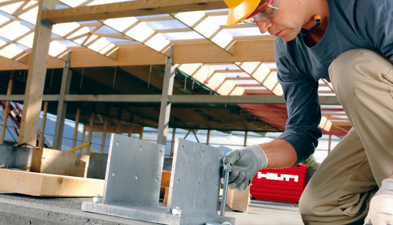 Arbeiter bei der Installation der Grundplatte mit Hilti Dübeln